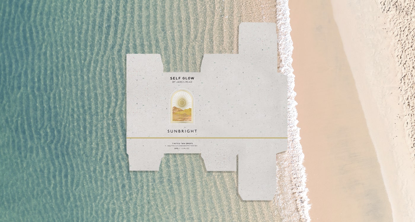 A flattened recycled cardboard packaging box from James Read's Self Glow, placed over an image of a beach and sea, representing the brand's sustainability efforts and commitment to eco-friendly materials.